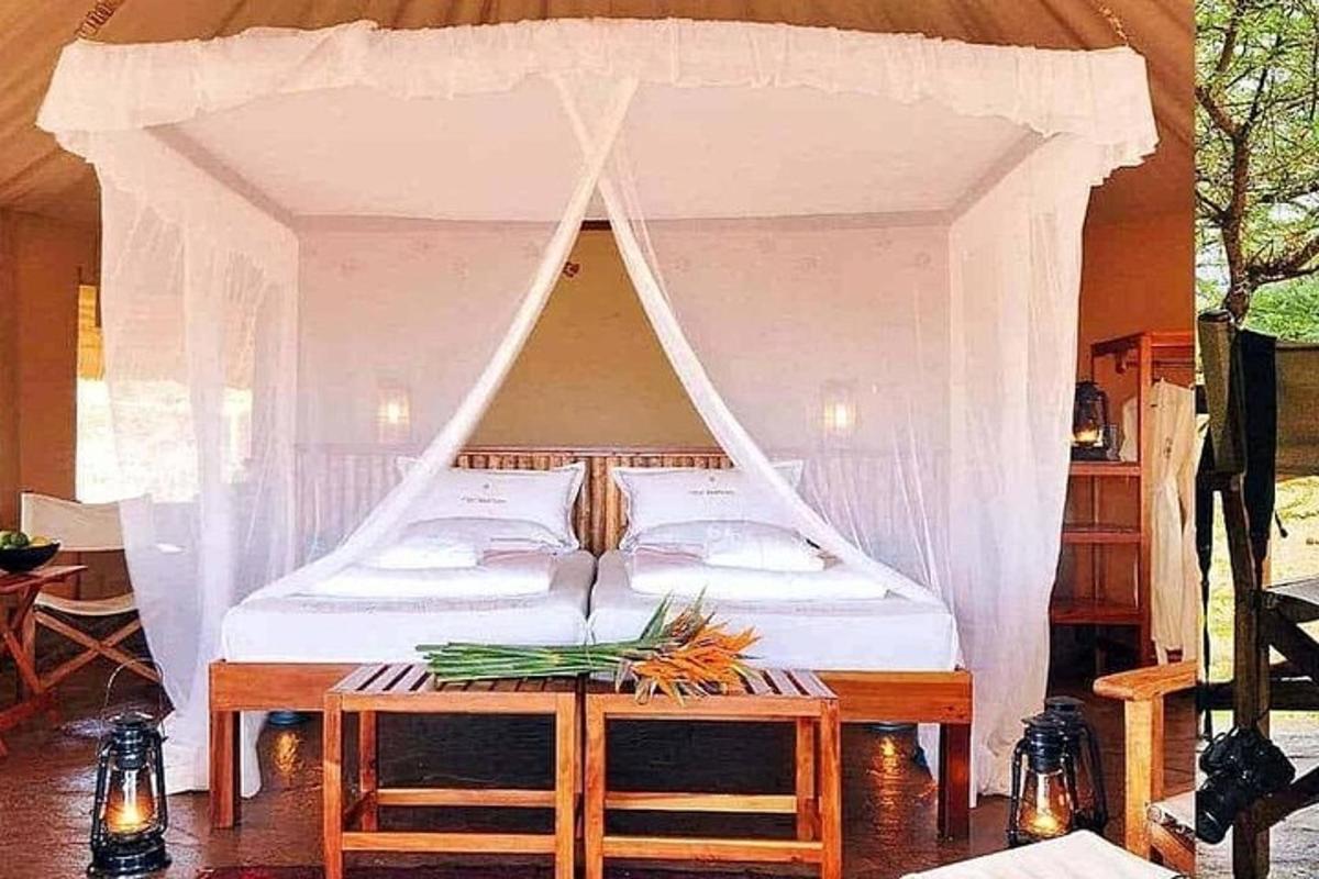 un letto con un baldacchino con un tavolo con dei fiori sopra