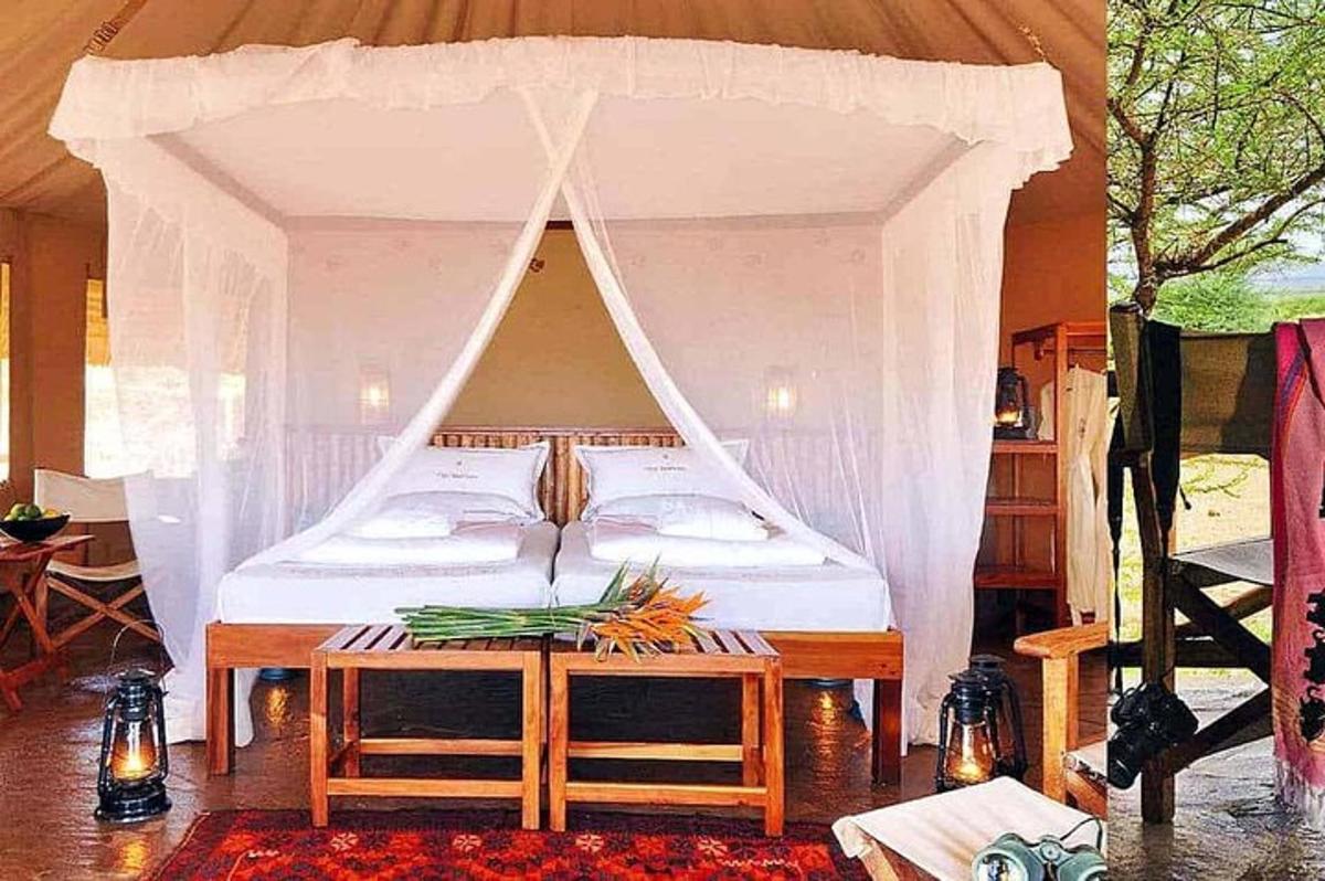 una camera da letto con un letto a baldacchino con un tavolo con dei fiori sopra