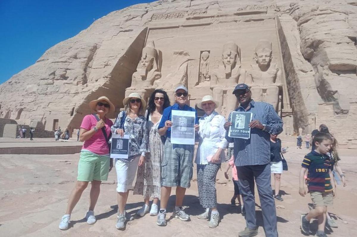 Un grupo de personas sosteniendo carteles frente a una estatua.