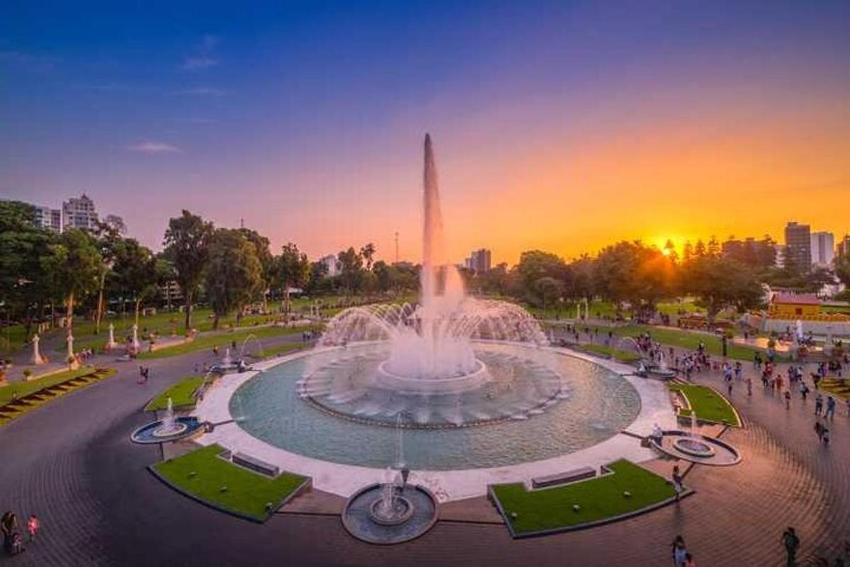 una fontana in un parco con il tramonto sullo sfondo