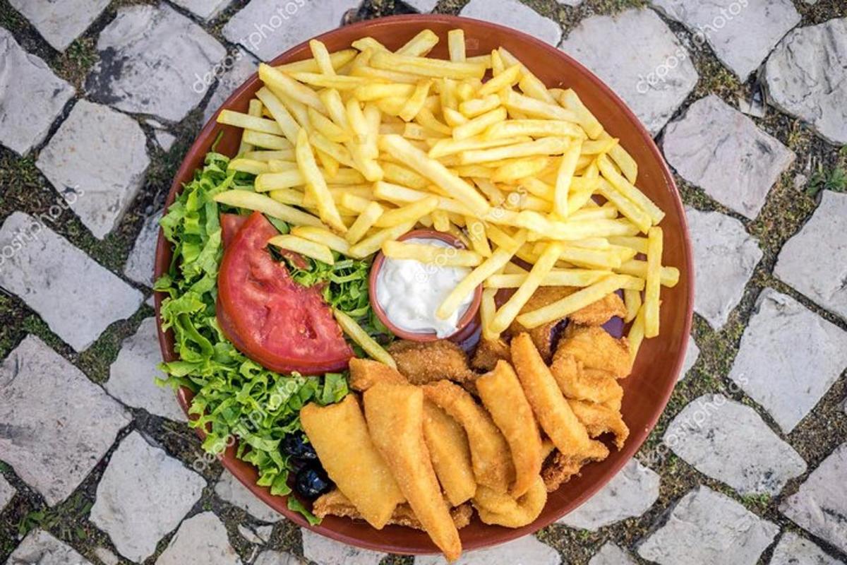 ein Teller mit Essen mit Salat und Pommes Frites