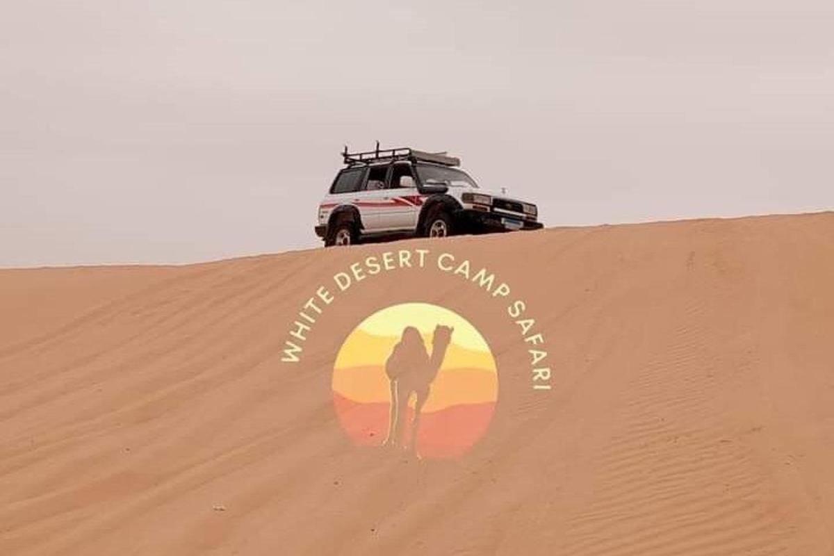 a person standing on top of a sand dune