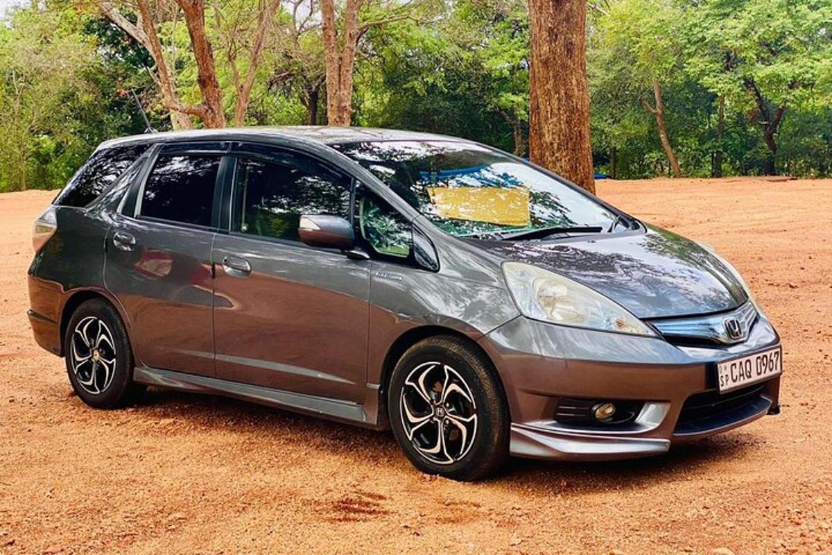 a small silver car parked on a dirt field