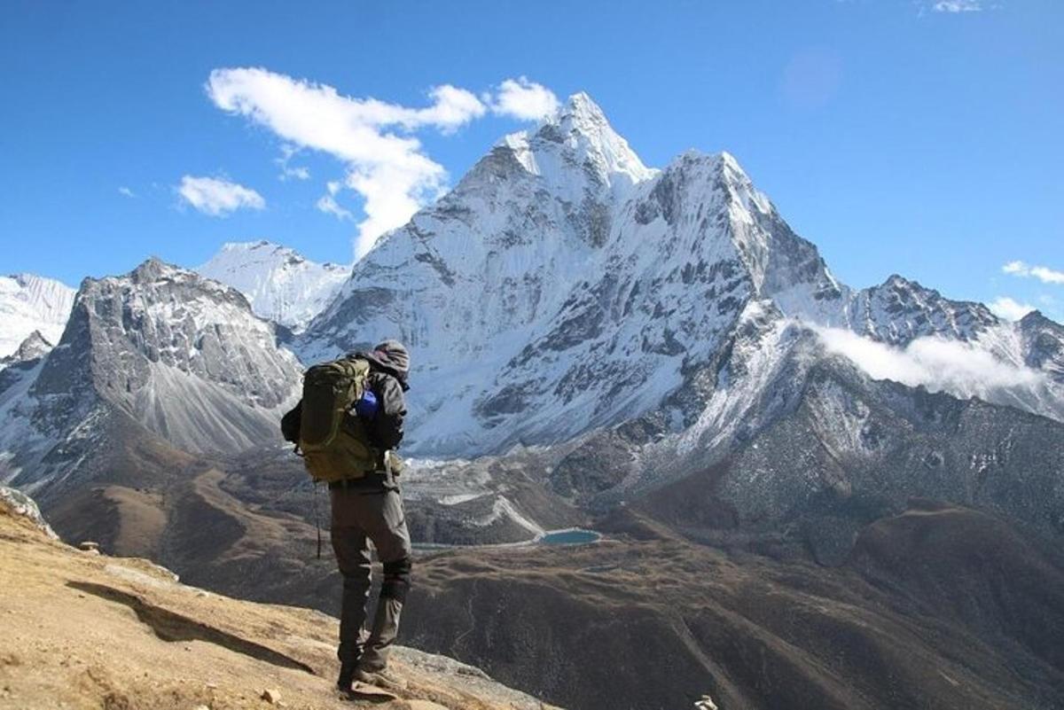 a man with a backpack standing on top of a mountain