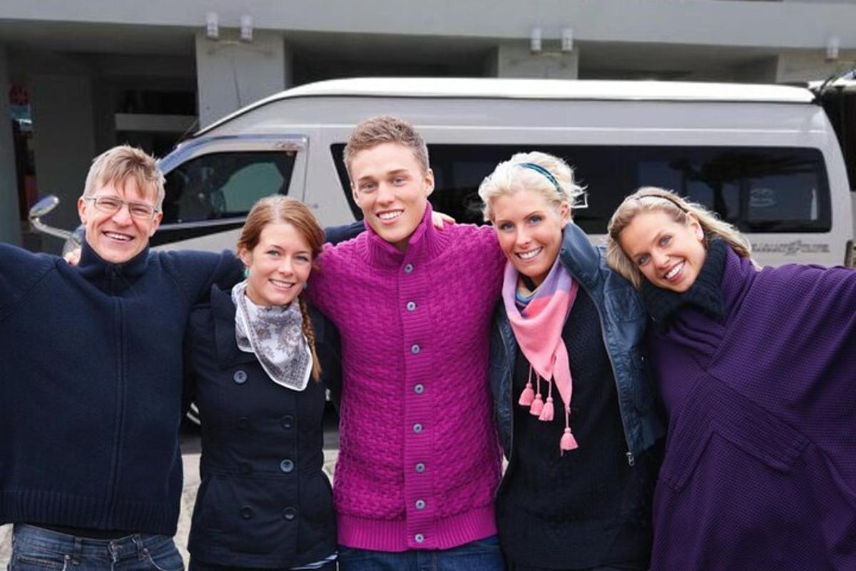 Un grupo de personas posando para una foto frente a una camioneta.