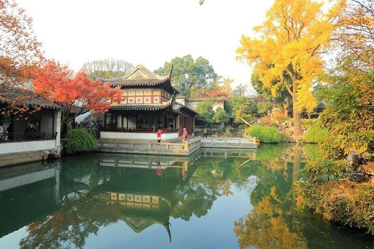 a chinese building with its reflection in a pond