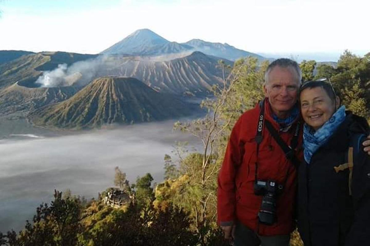 Un hombre y una mujer de pie frente a una montaña