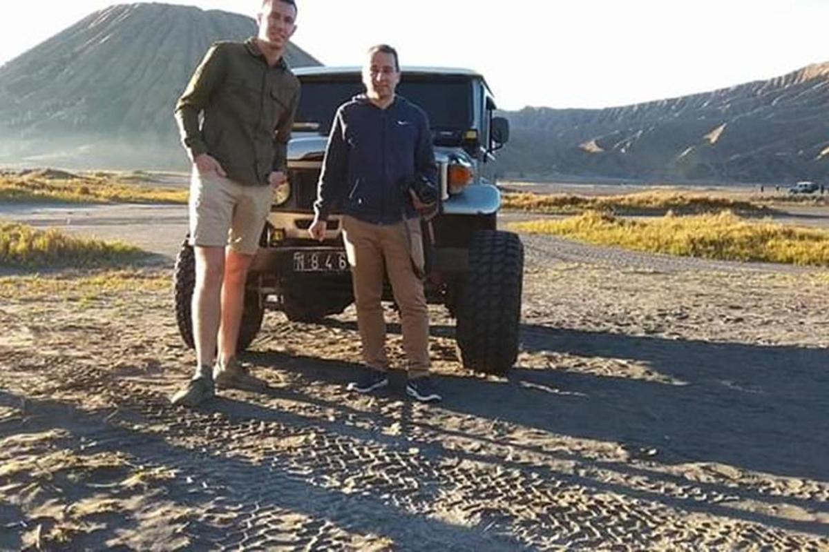 dois homens parados ao lado de um caminhão no deserto
