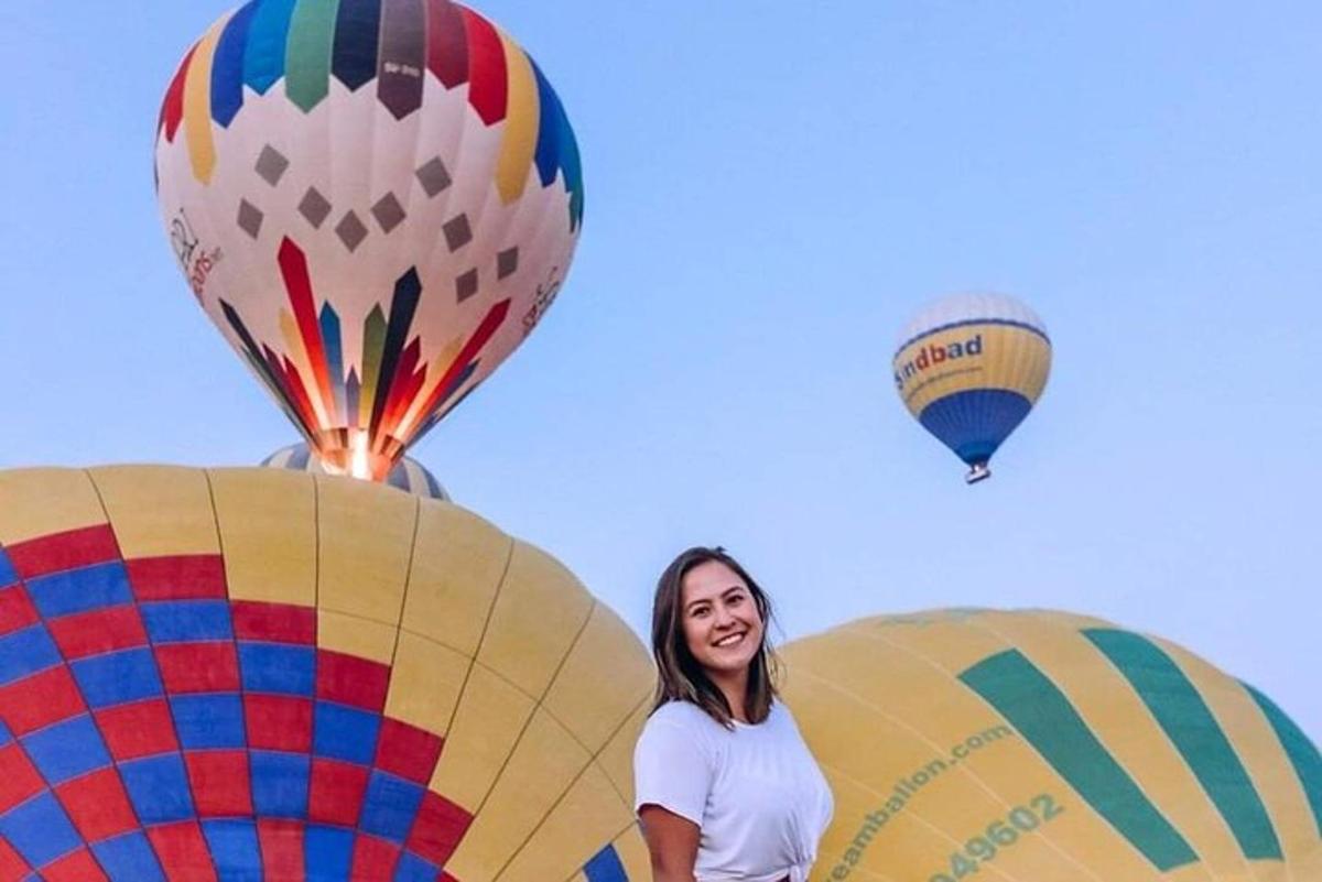 žena stojící vedle tří horkovzdušných balónů