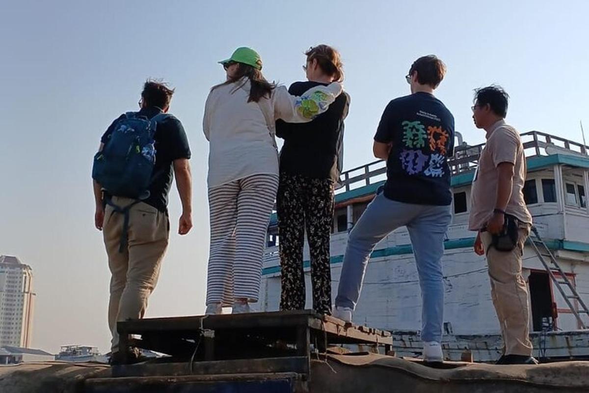 un gruppo di persone in piedi in cima a una barca