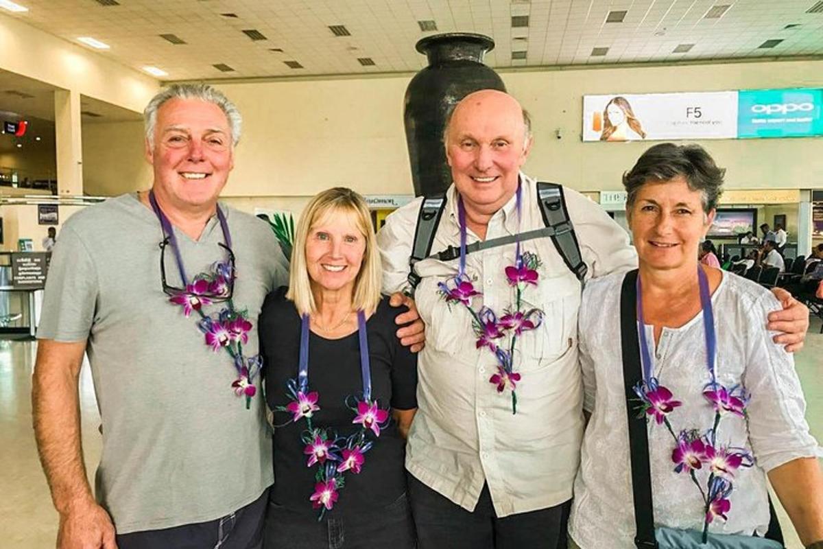 three people posing for a picture with flowers on their necks