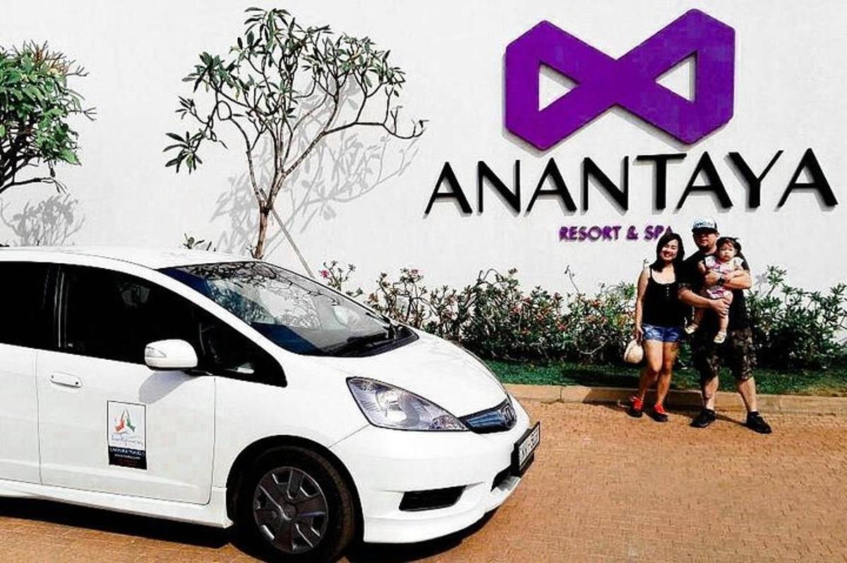 a group of people standing next to a white car