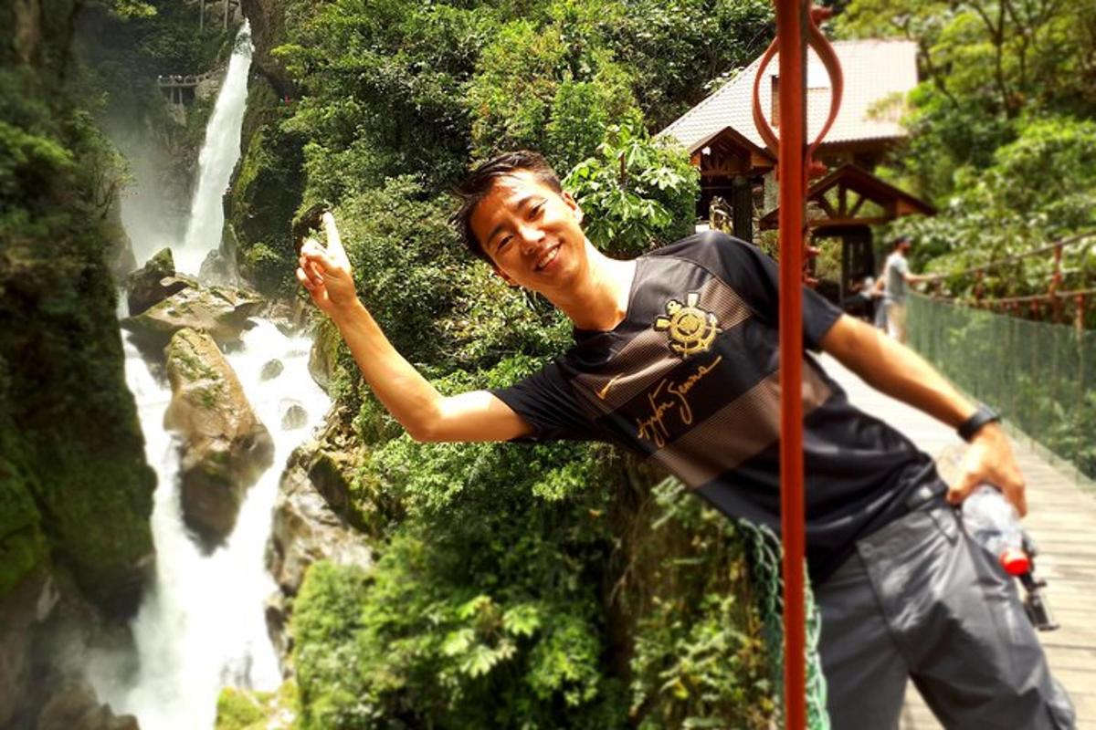 a man standing in front of a waterfall