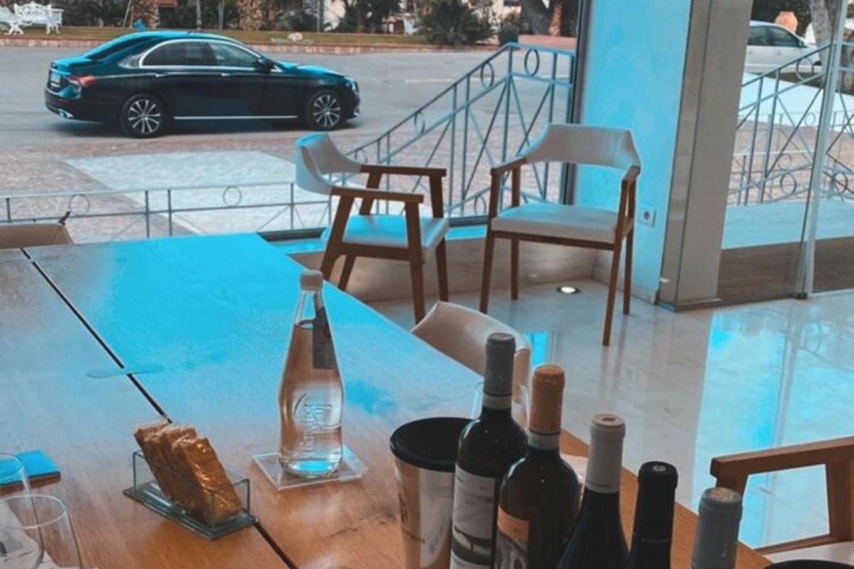 meja dengan botol dan kerusi wain serta sebuah kereta