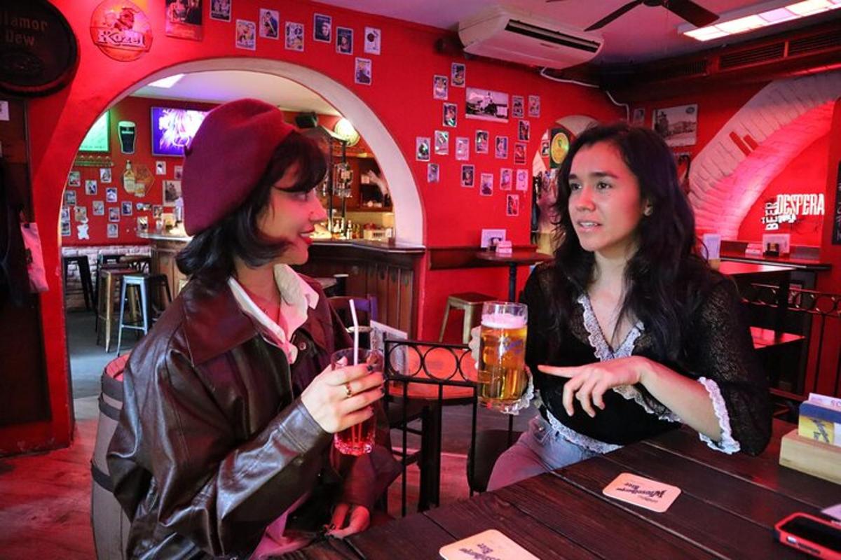 dvě ženy sedící u baru s drinky