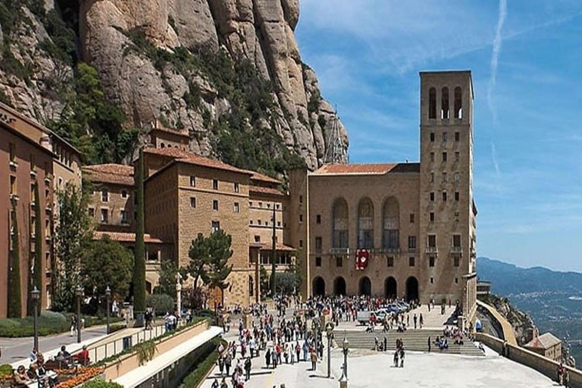 un gruppo di persone che camminano in una città con una montagna