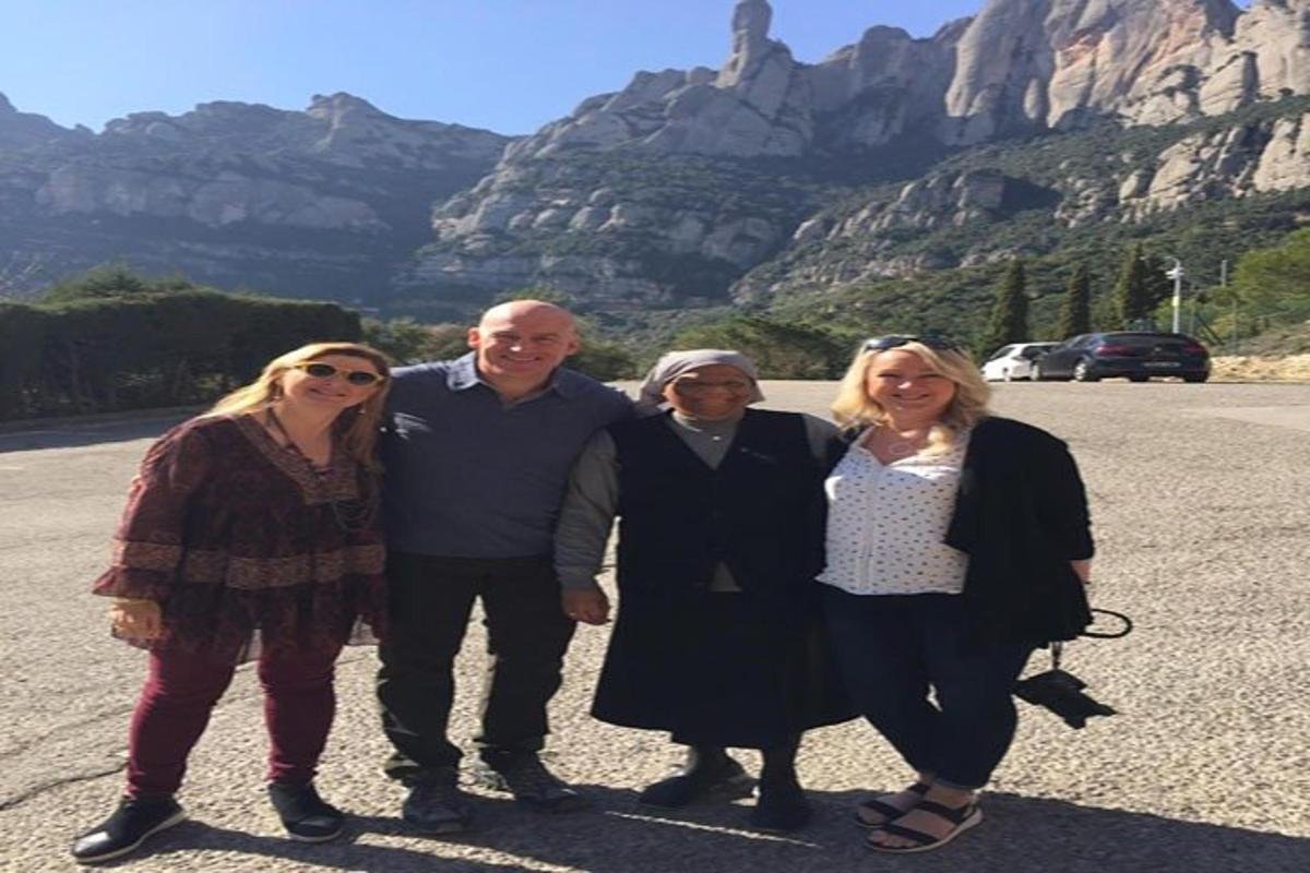 un gruppo di persone in piedi di fronte a una montagna