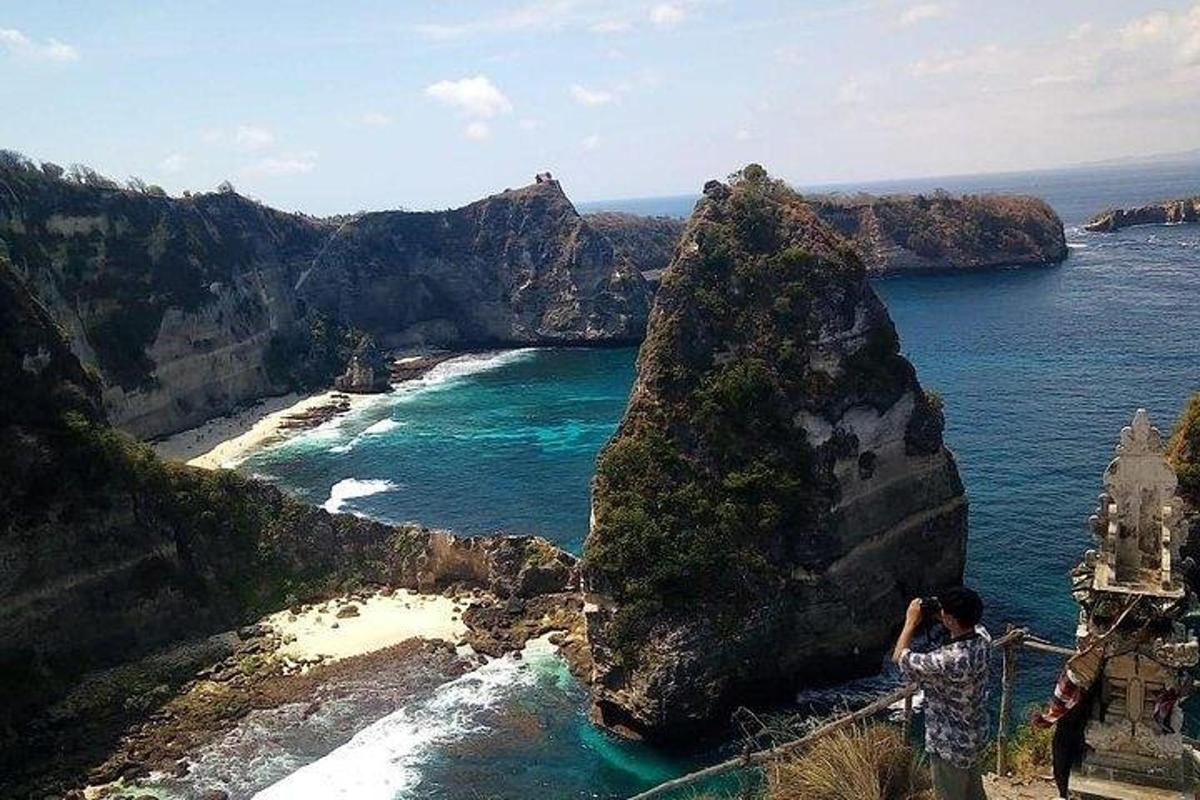 un home dret amb una corda lligada a una roca a l'oceà