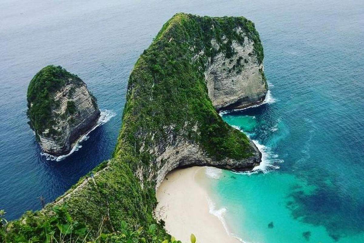una gran formació rocosa a l'oceà amb una platja