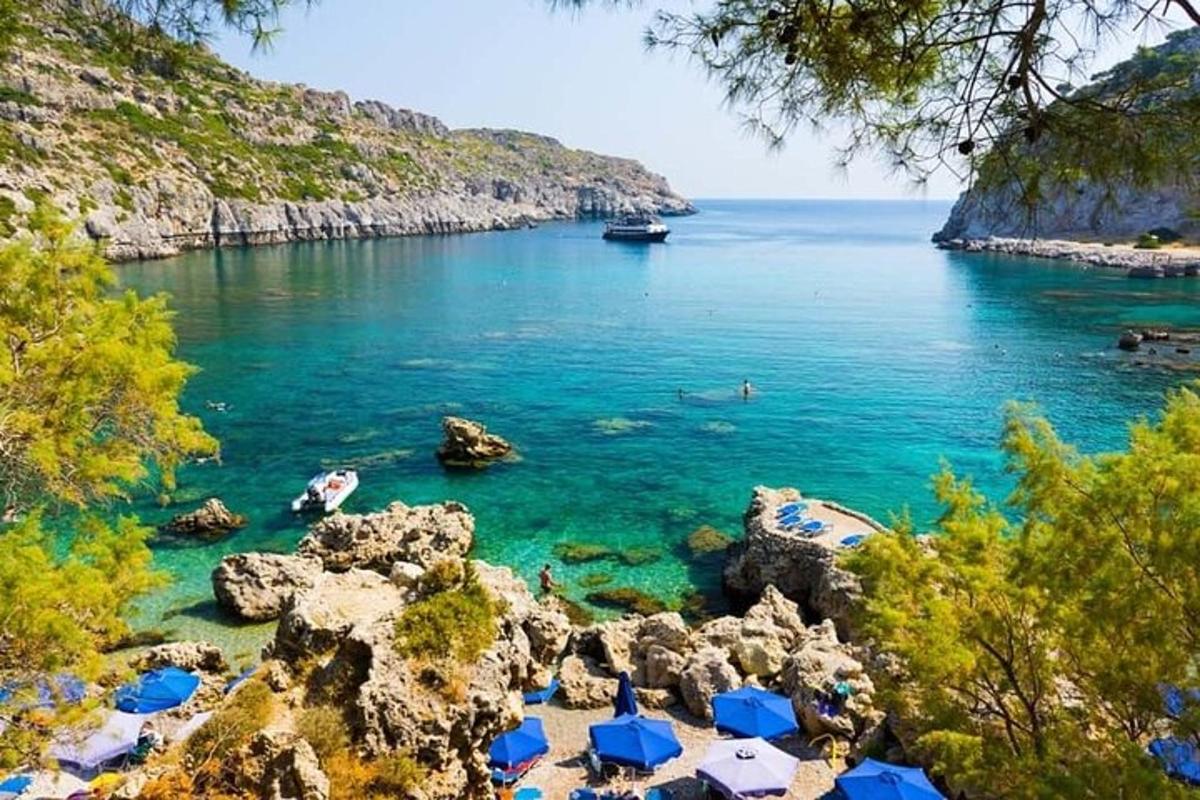 a beach with blue umbrellas and people in the water