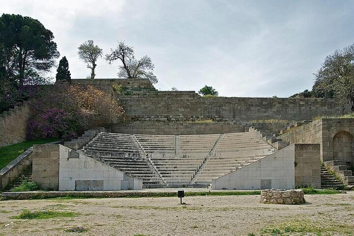 an empty amphitheater with a stone wall and stairs