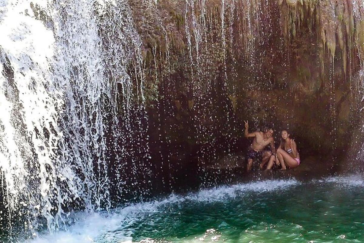 two people sitting in front of a waterfall