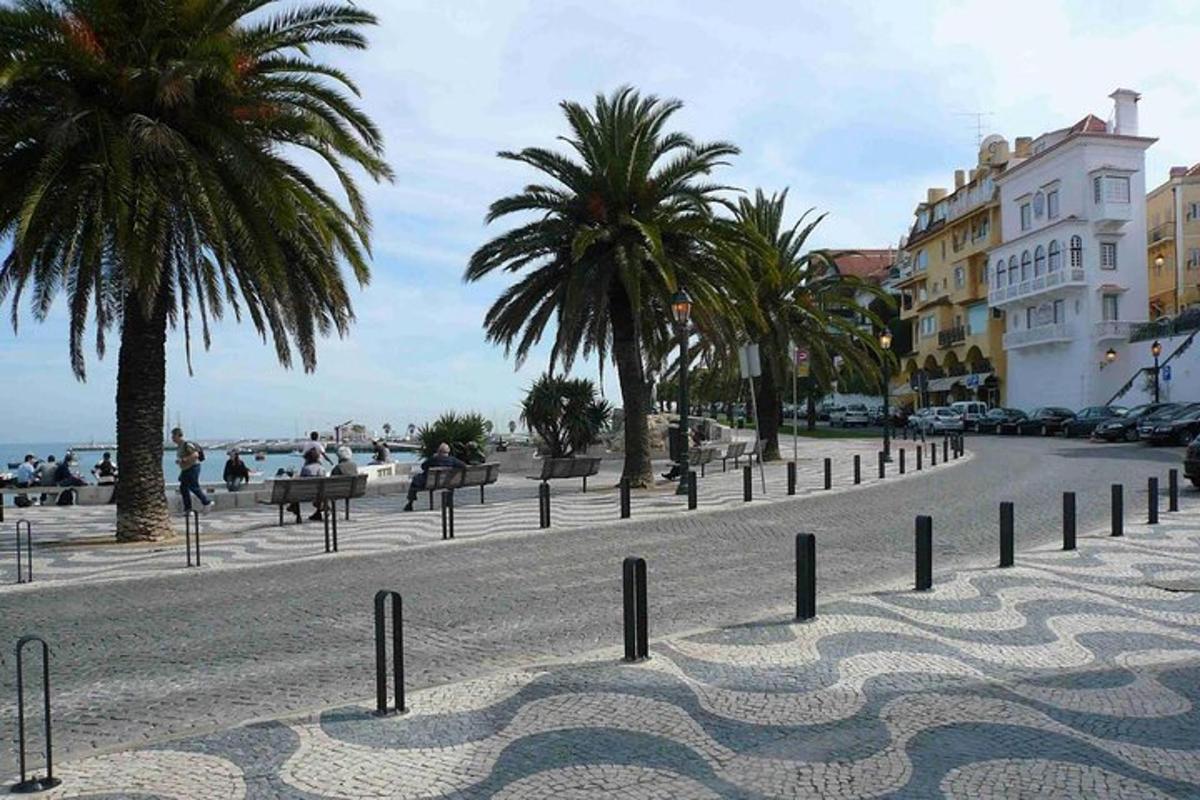 una strada acciottolata con palme e una spiaggia