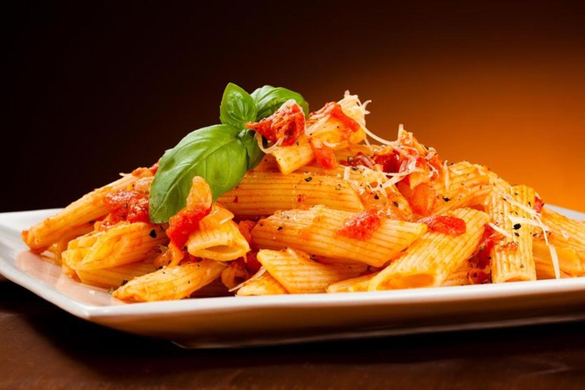 un piatto di pasta con guarnizione di basilico verde