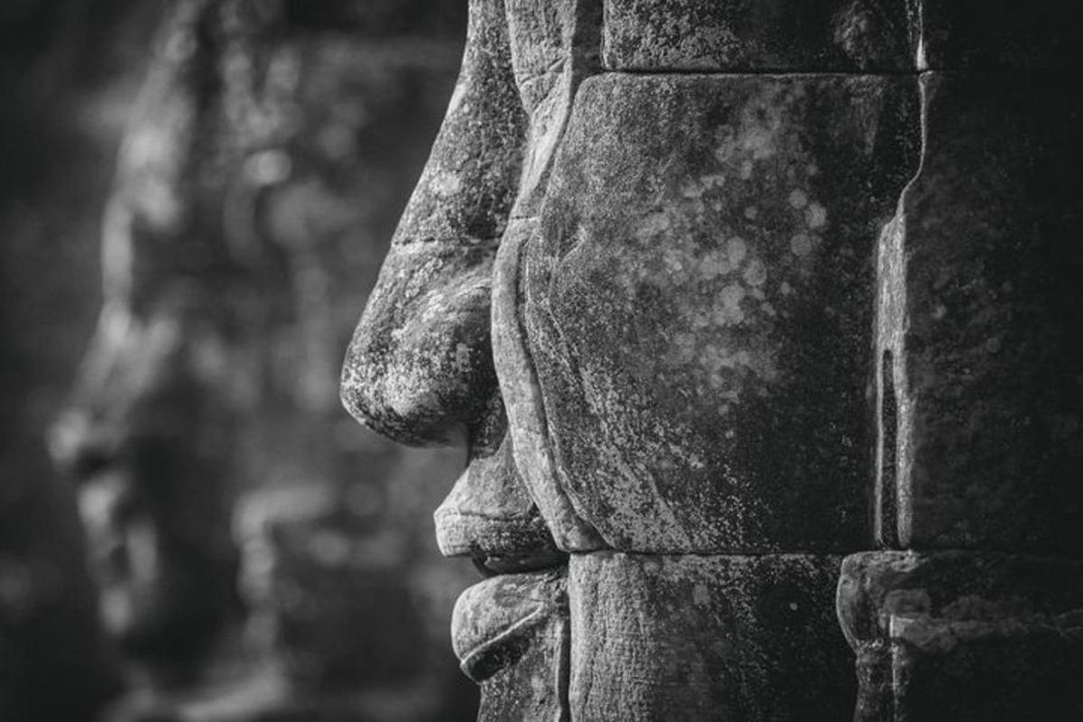 una statua di una persona in piedi su un muro di pietra