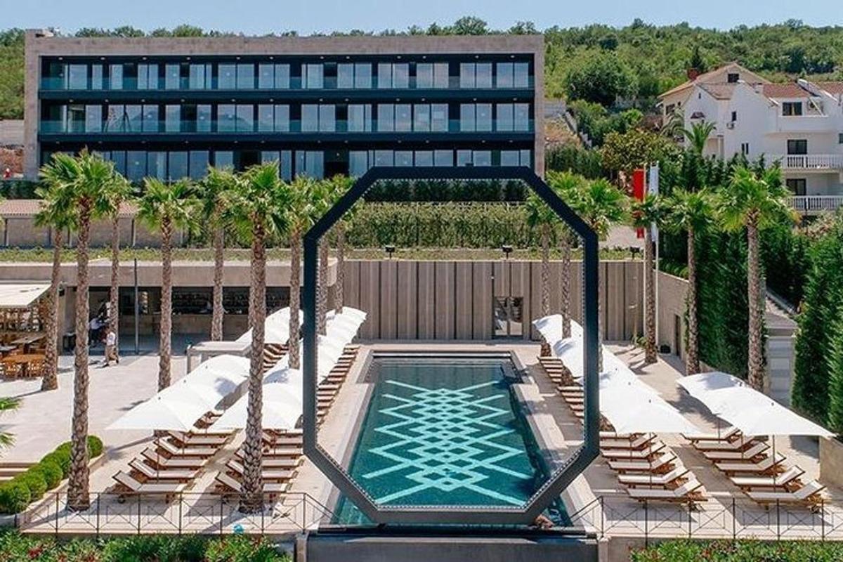 una vista dall'alto di una piscina con sedie e un edificio