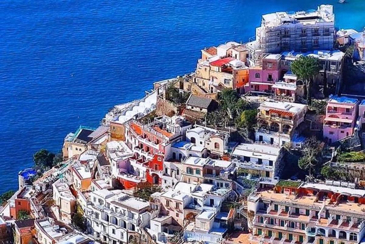 μια ομάδα σπιτιών σε έναν λόφο δίπλα στο νερό