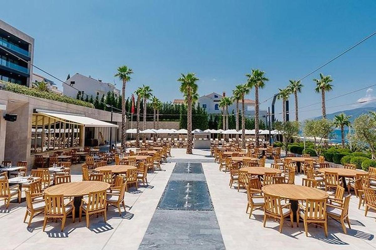 un patio vuoto con tavoli, sedie e palme