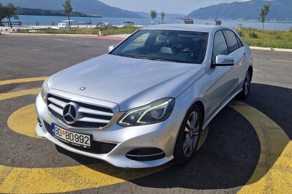 um carro Mercedes Benz branco estacionado em um estacionamento