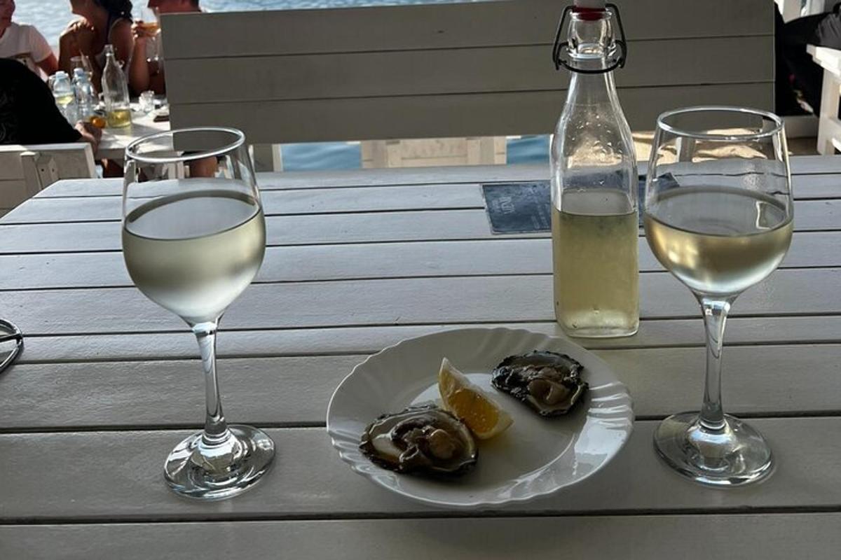 ein Tisch mit zwei Gläsern Wein und einem Teller mit Essen