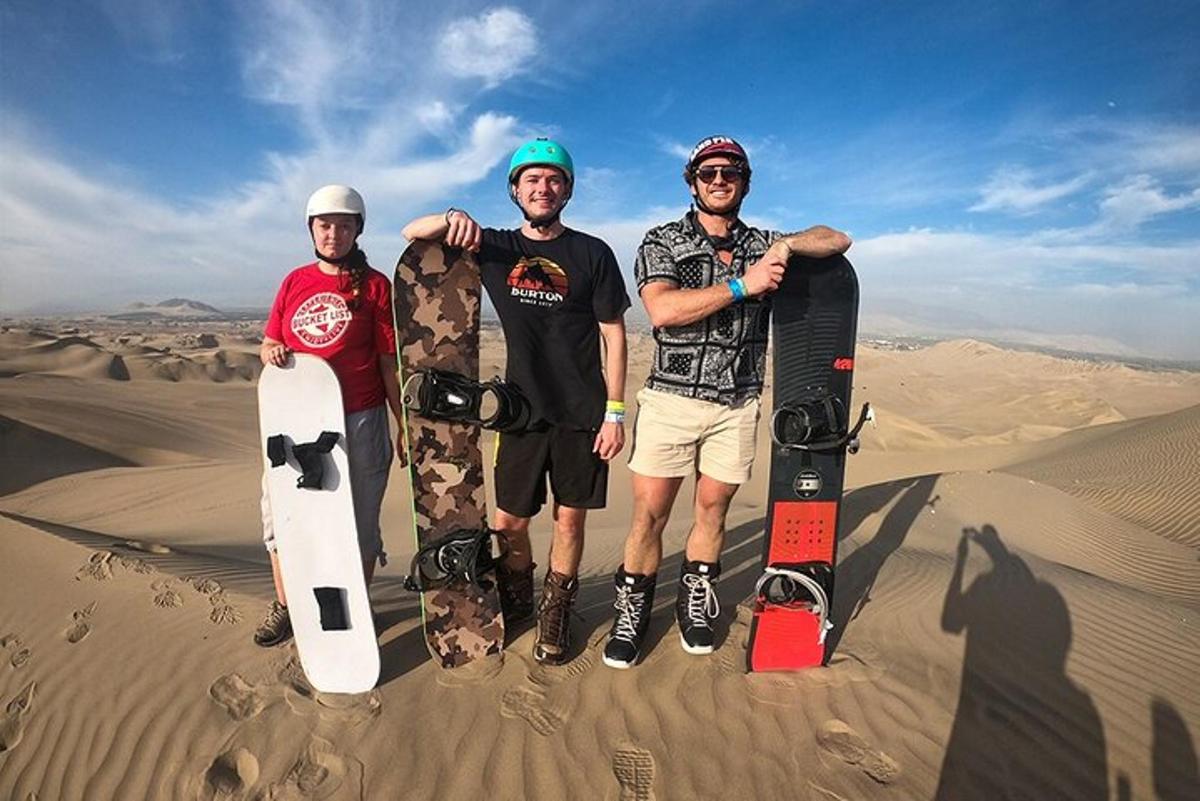 tři muži stojící v poušti se svými snowboardy