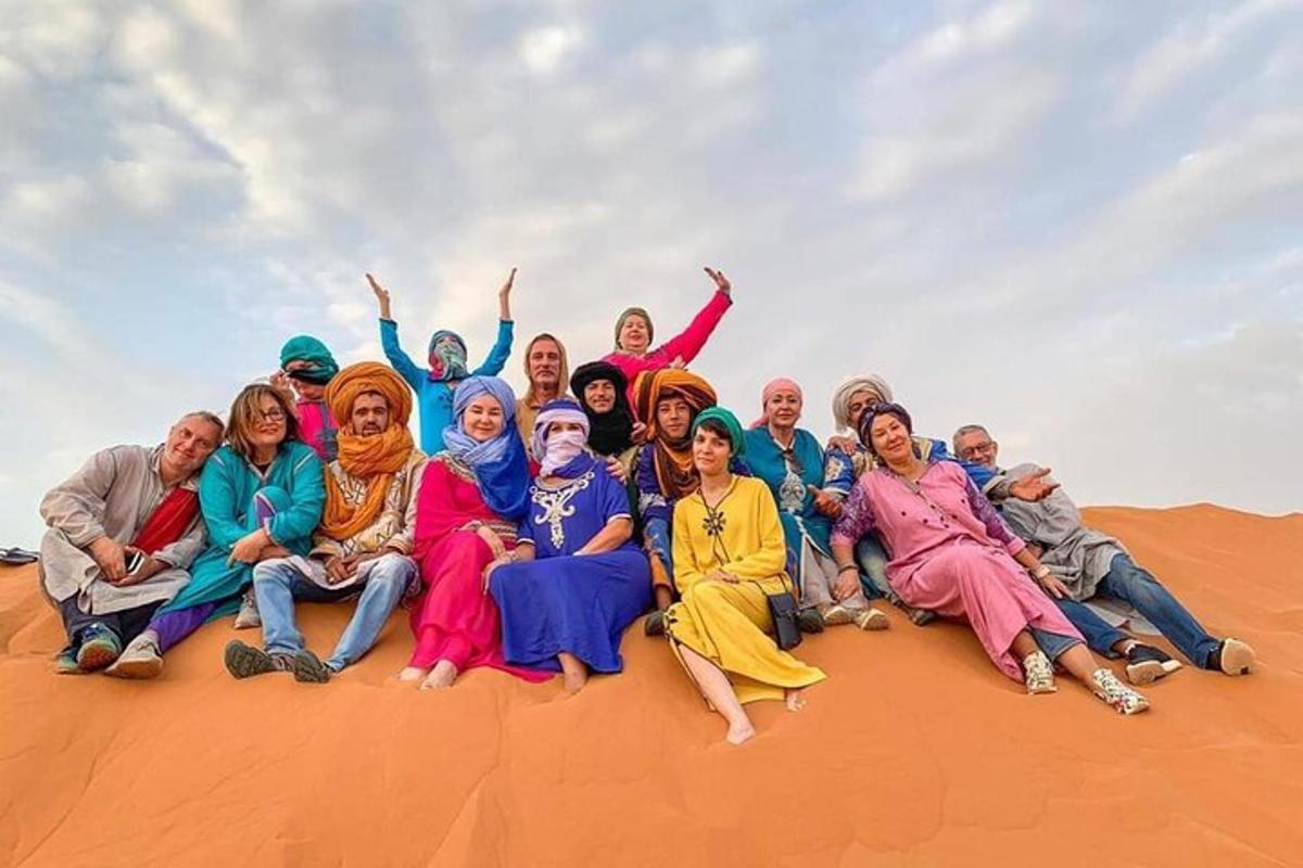 sekelompok orang berpose untuk foto di padang pasir