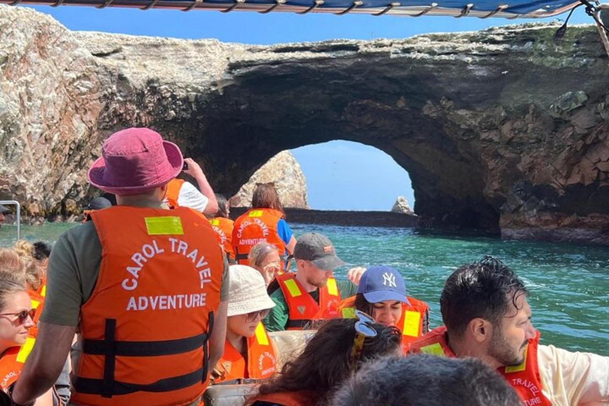 a group of people in a boat in front of a cave