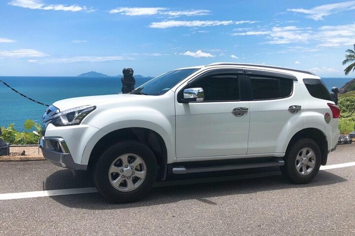 bílé SUV zaparkované na silnici poblíž oceánu