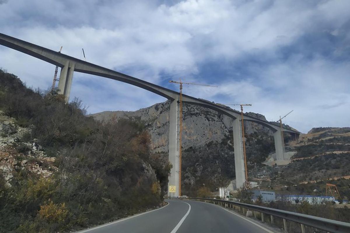 un'autostrada con un ponte sul fianco di una montagna