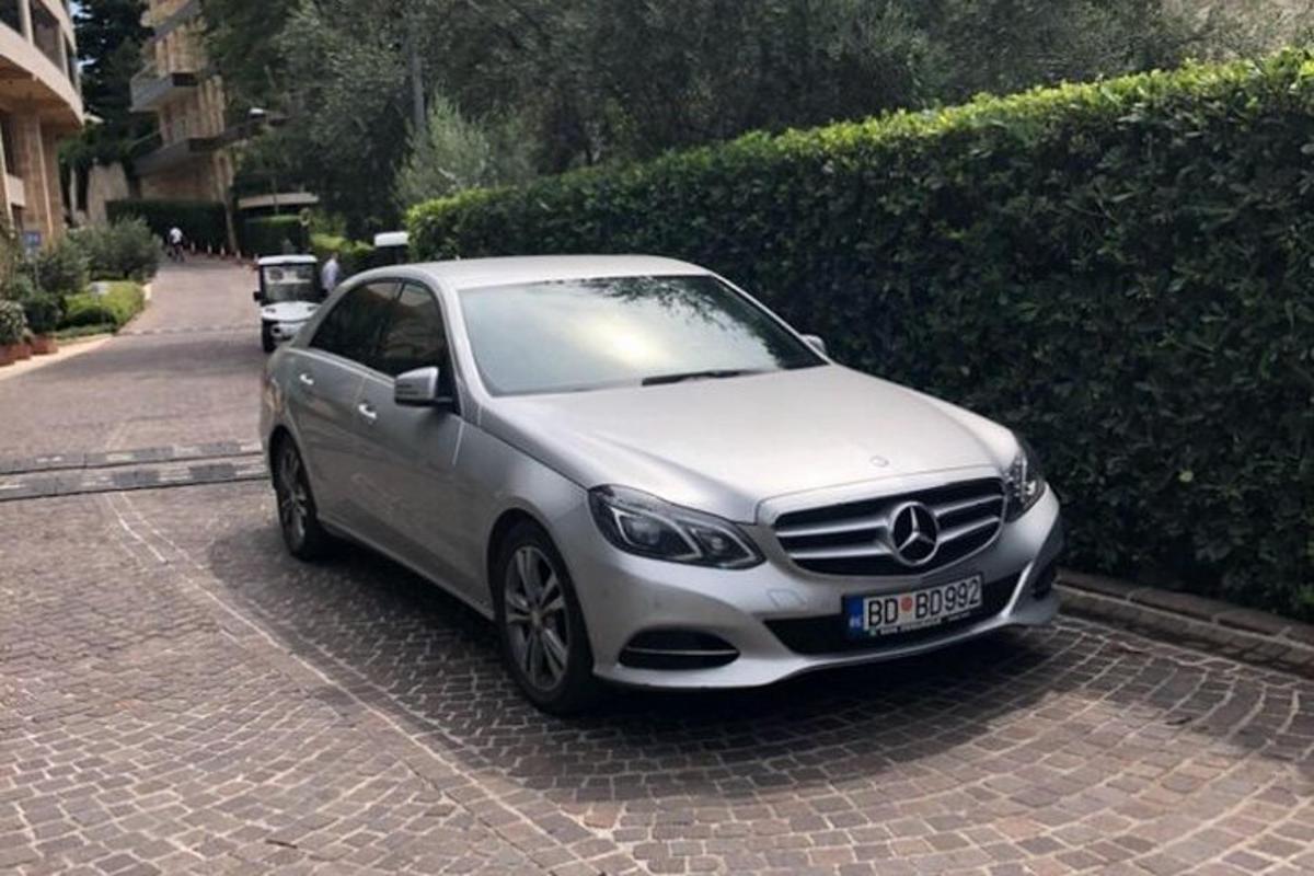un'auto argentata parcheggiata su una strada accanto a una siepe