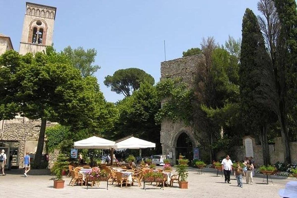 un grup de taules i cadires i un edifici amb una torre