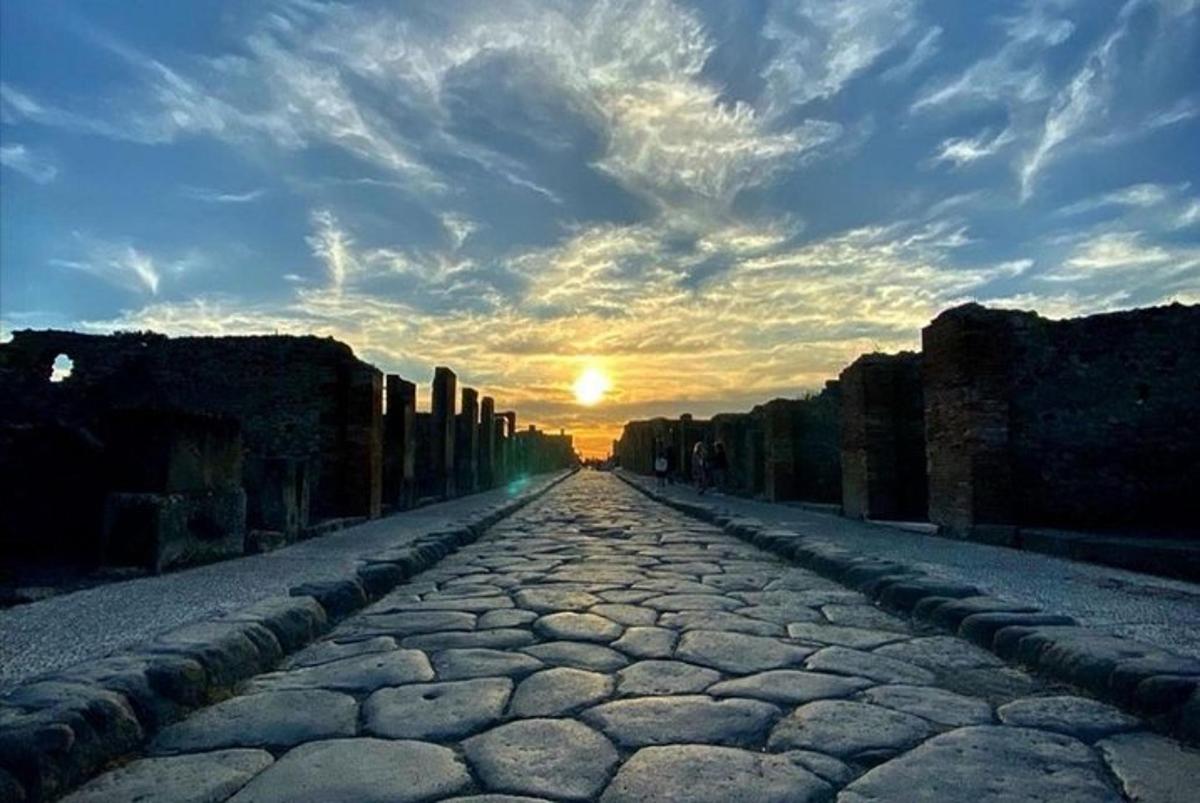 a cobble stone road with the sunset in the background