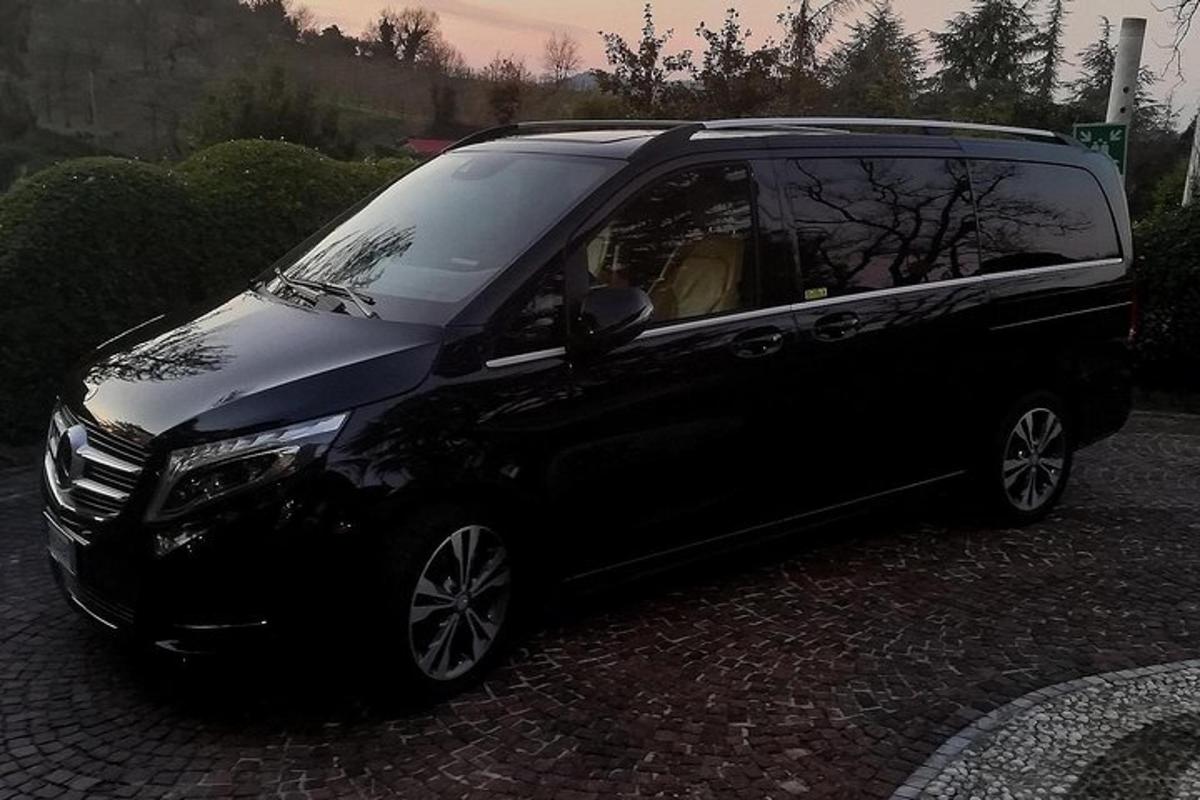 ein schwarzes Auto, das auf einer Ziegelsteinstraße geparkt ist