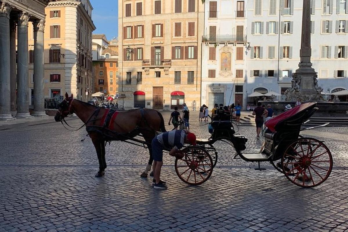 un uomo che rifornisce di carburante una carrozza trainata da cavalli su una strada