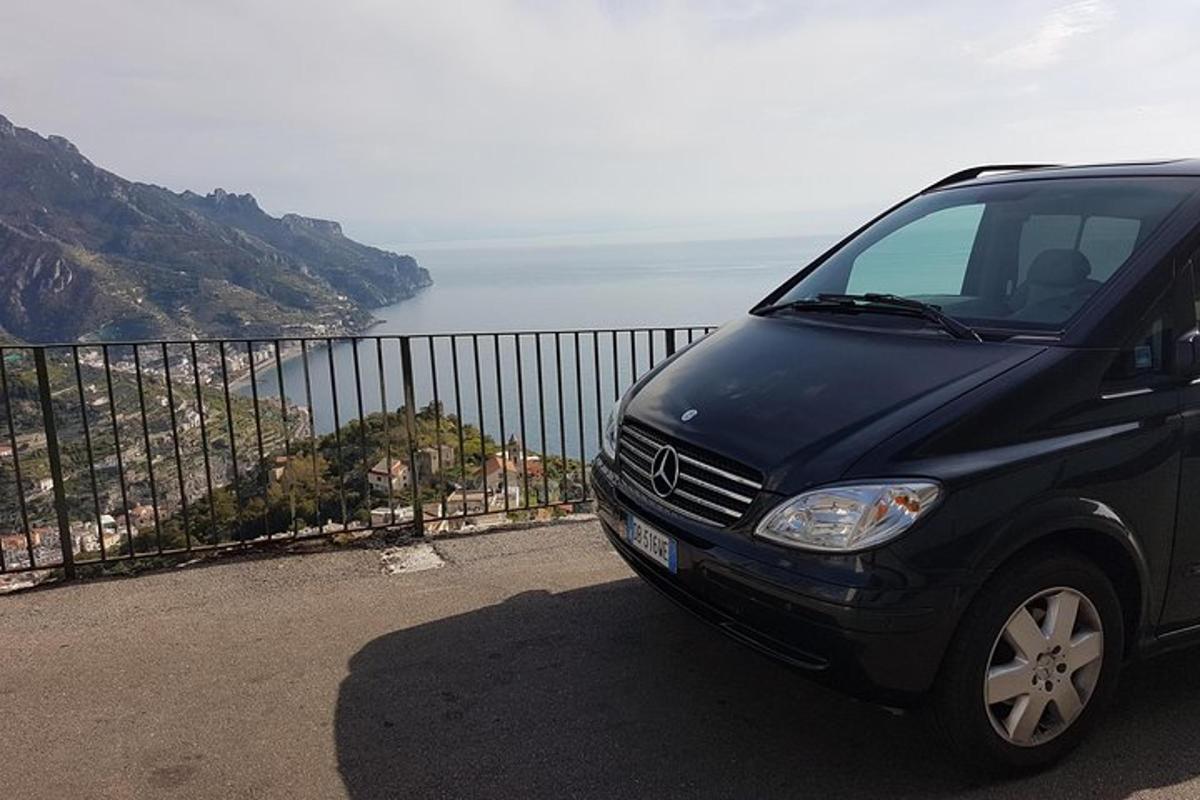 Un coche negro estacionado frente al océano