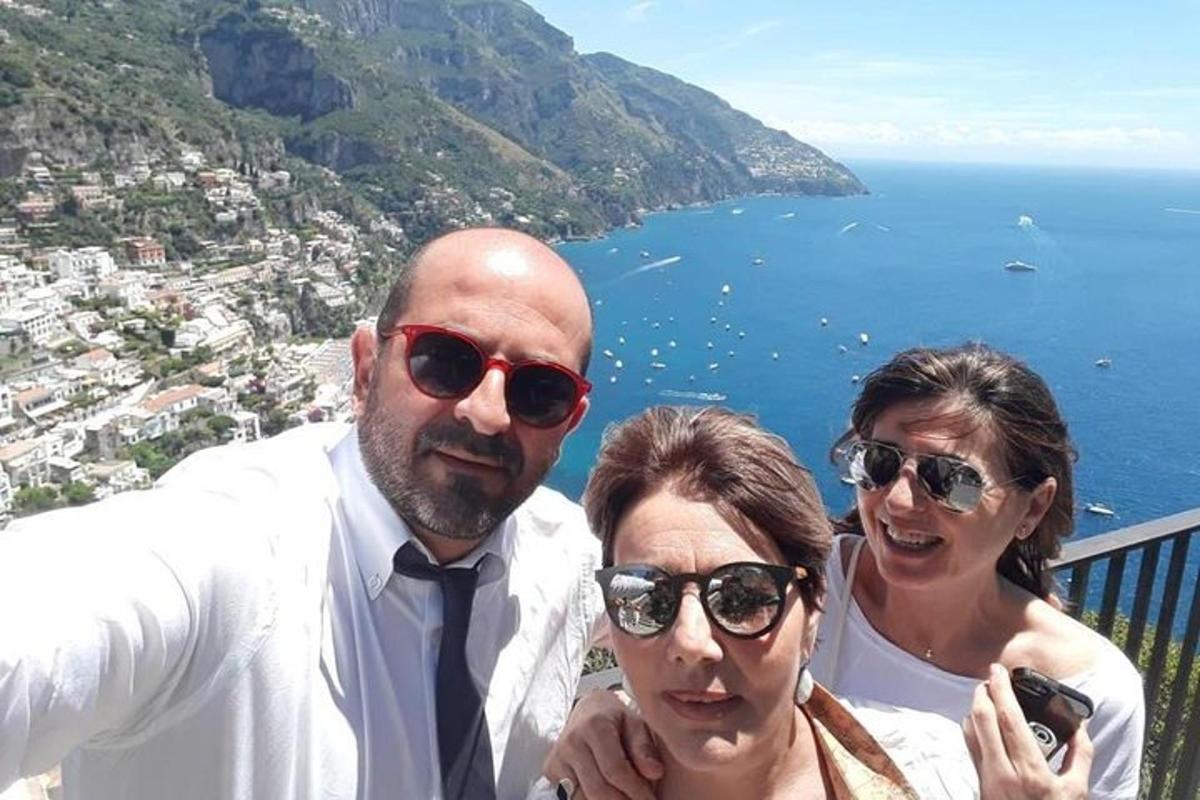 un gruppo di tre persone in piedi su un balcone con vista sull'oceano