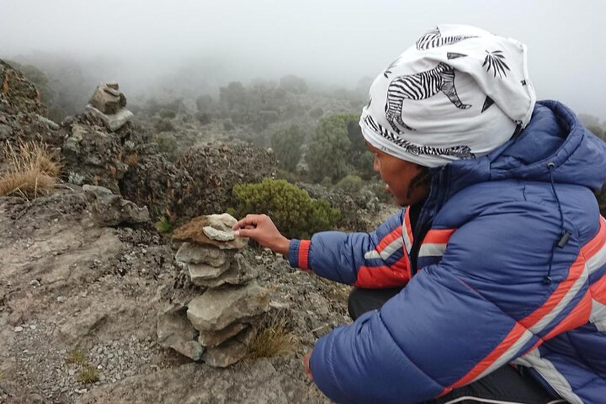 una persona che costruisce una formazione rocciosa su una montagna