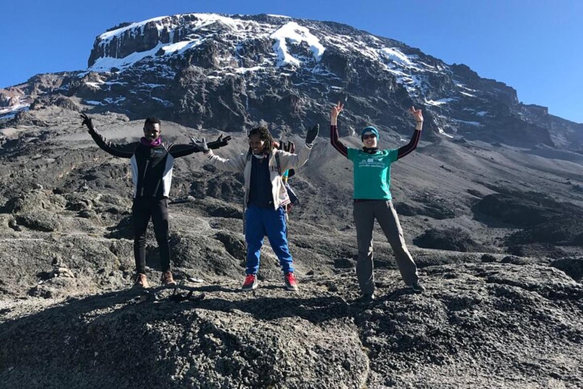 tre persone in piedi sulla cima di una montagna