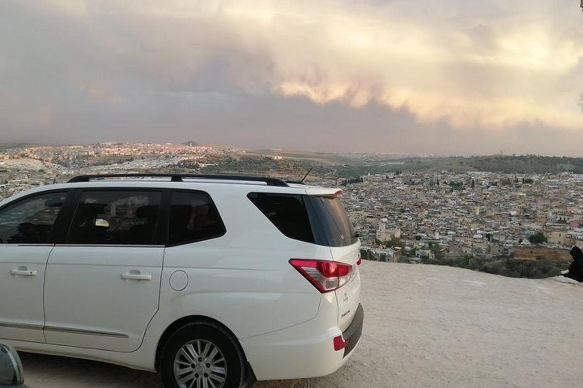 бял SUV, паркиран на върха на планина