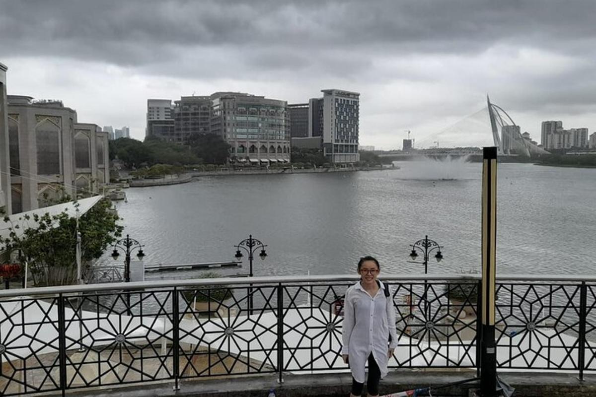 a woman standing on a bridge near a body of water